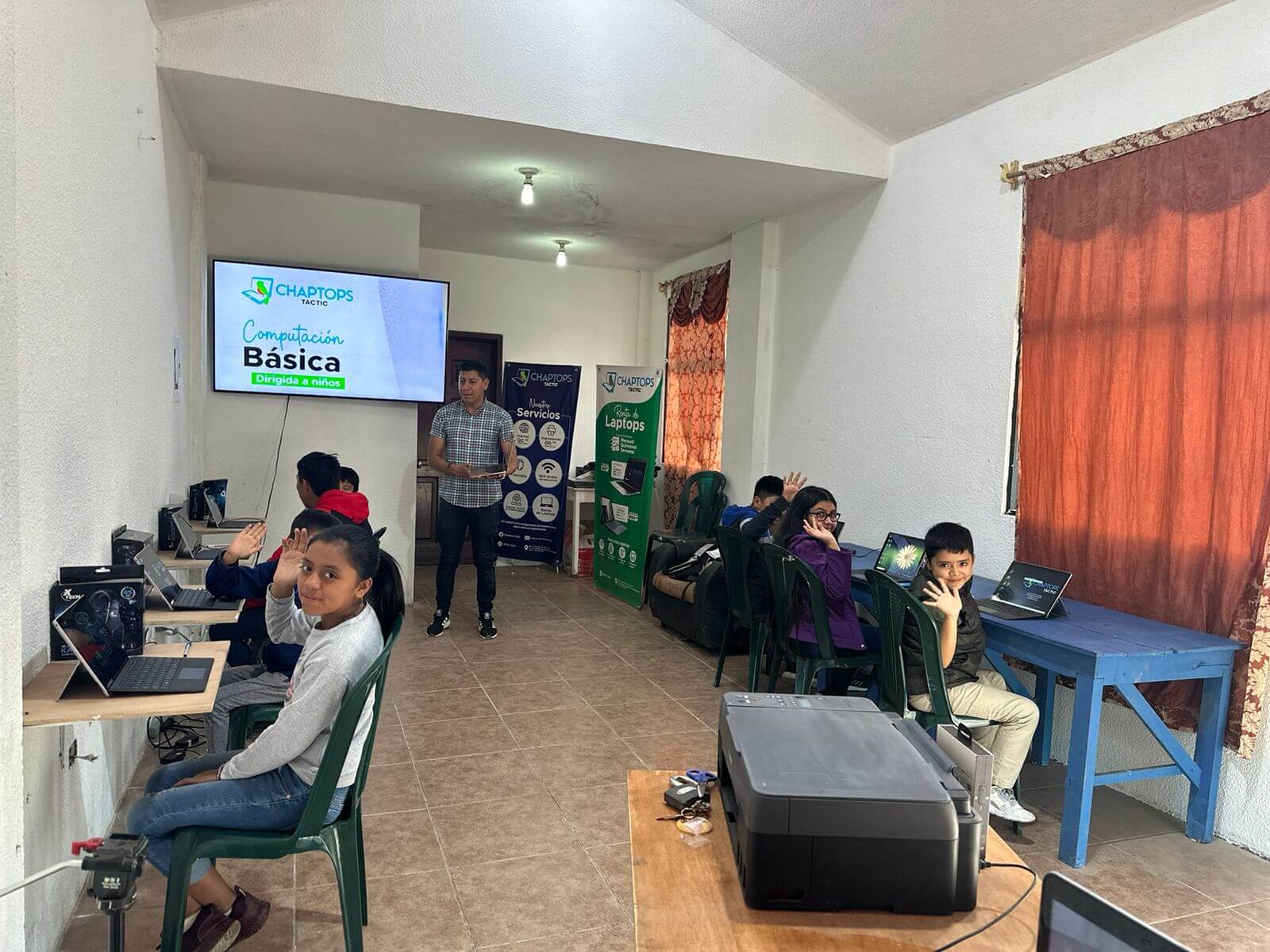 The interior of free Chaptops walk-in computer lab in Tactic in Guatemala with a class of elementary school students receiving instruction from Oscar Buc.