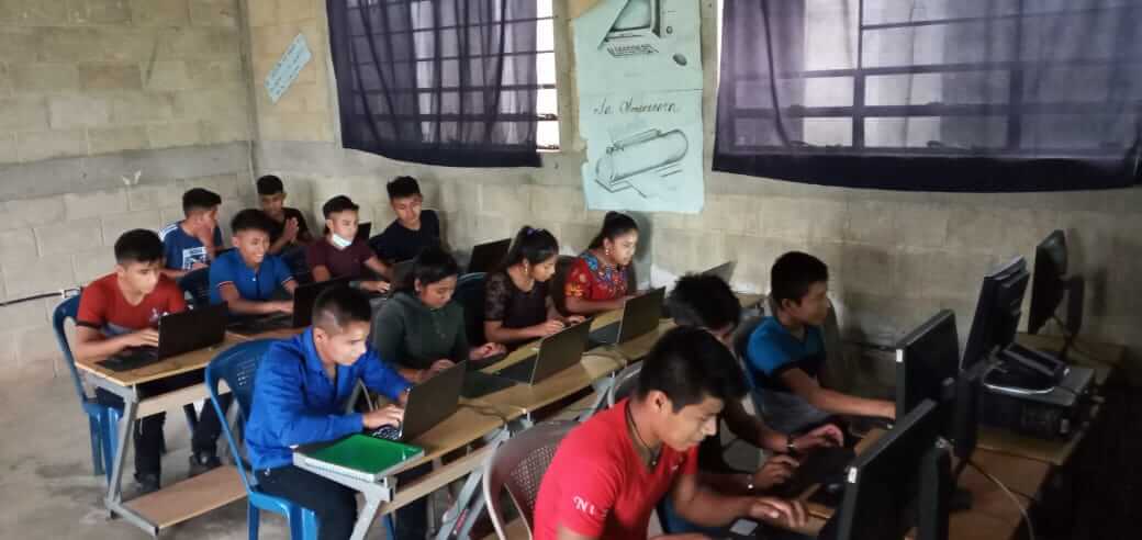 Thirteen students in the computer classroom equiped by Chaptops at Instituto Maya Comunitario K’amolb’e in Alta Verapaz, Guatemala.