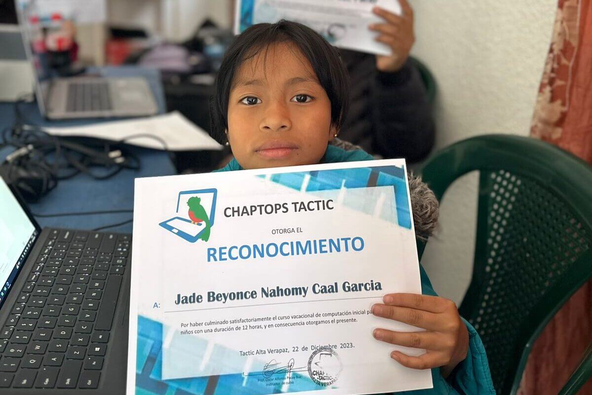 An elementary-school girl shows off her certificate for completing Chaptops' first computer camp in Tactic, Alta Verapaz, Guatemala.